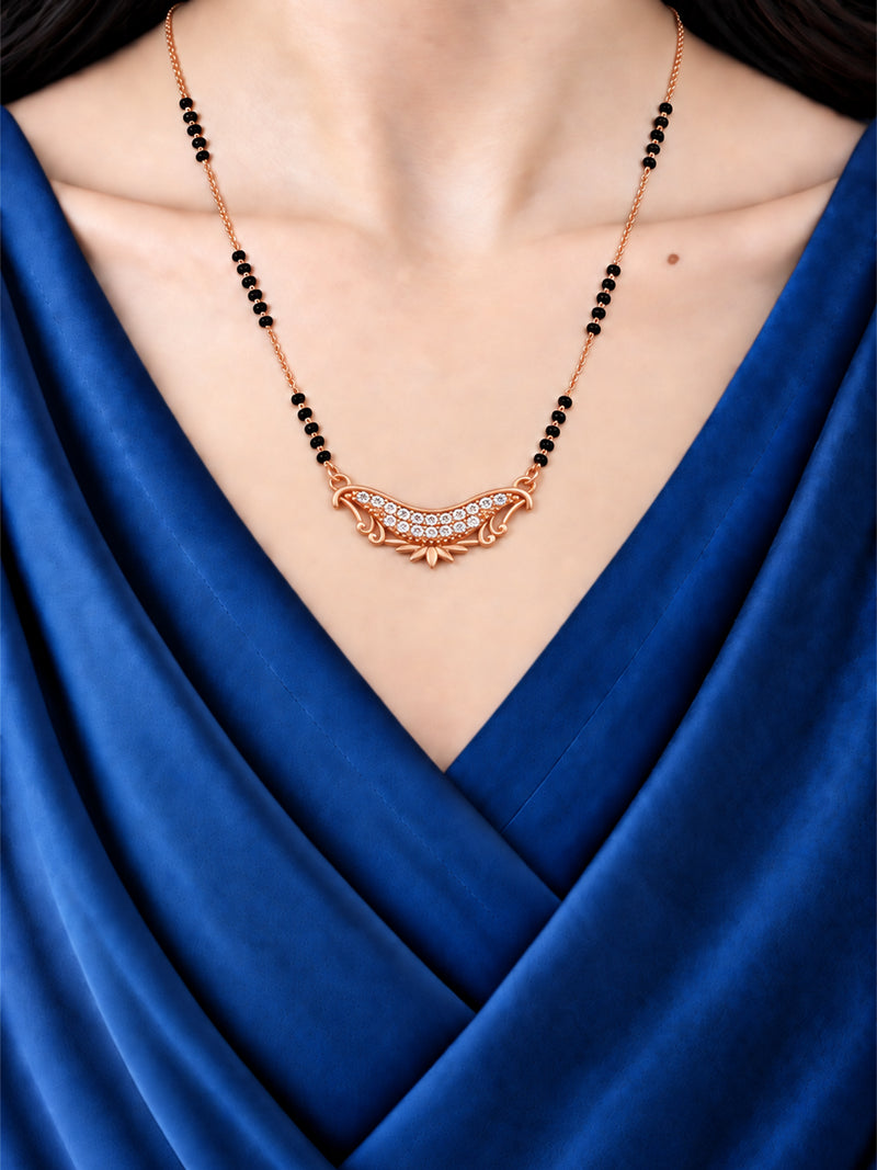 Crescent Lotus rose gold mangalsutra with black beads shown worn with a blue outfit