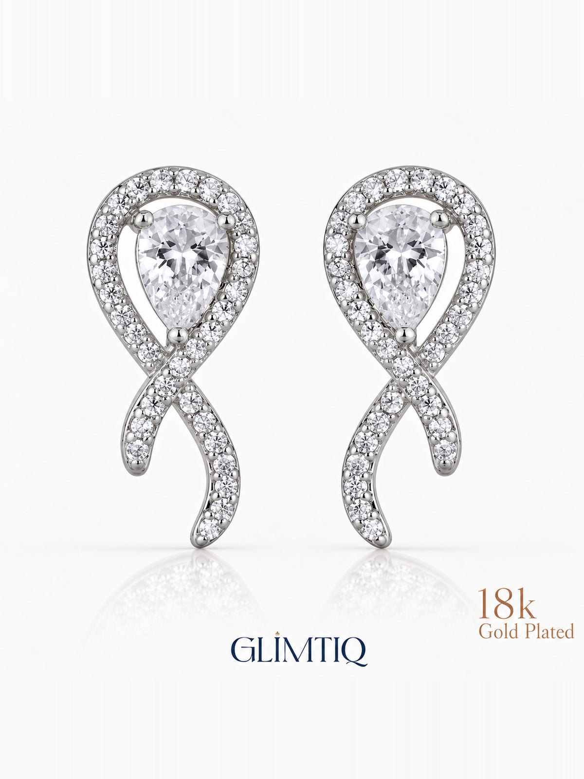 Close view of crossed ribbon stud earrings with clear teardrop centres and sparkling silver-toned fronts