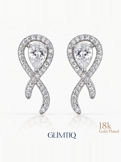 Close view of crossed ribbon stud earrings with clear teardrop centres and sparkling silver-toned fronts