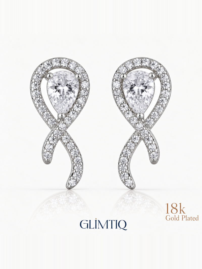 Close view of crossed ribbon stud earrings with clear teardrop centres and sparkling silver-toned fronts