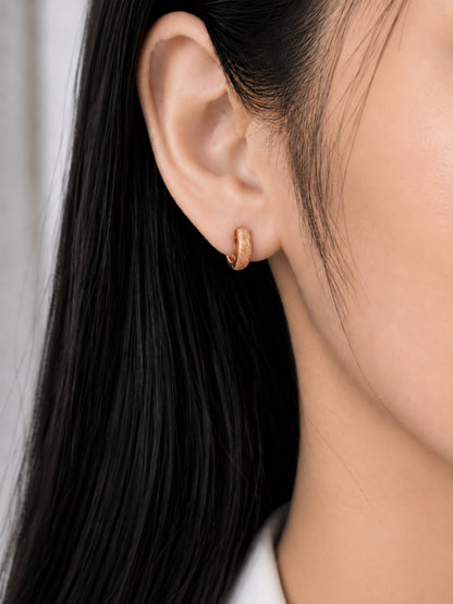 Everyday Gleam 18K Rose Gold Plated Huggie Earrings worn on a model's ear