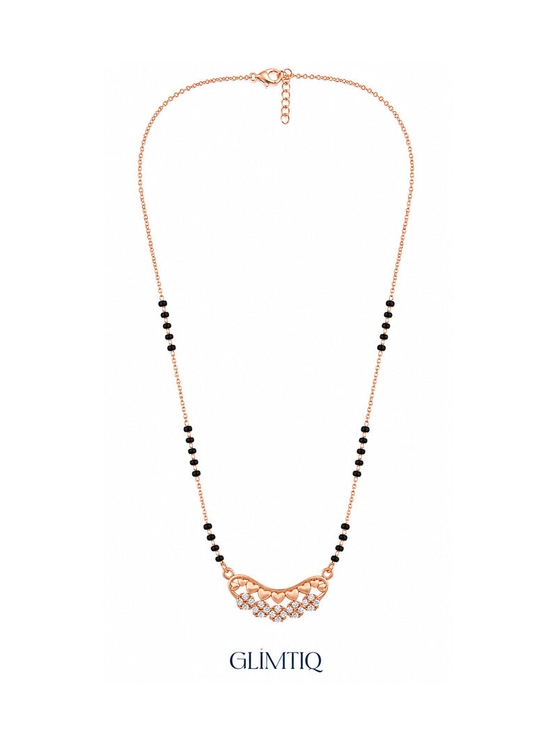 Full rose gold mangalsutra showing black bead sections, curved row of rose-gold hearts above sparkling flower clusters, lobster clasp and extension chain.