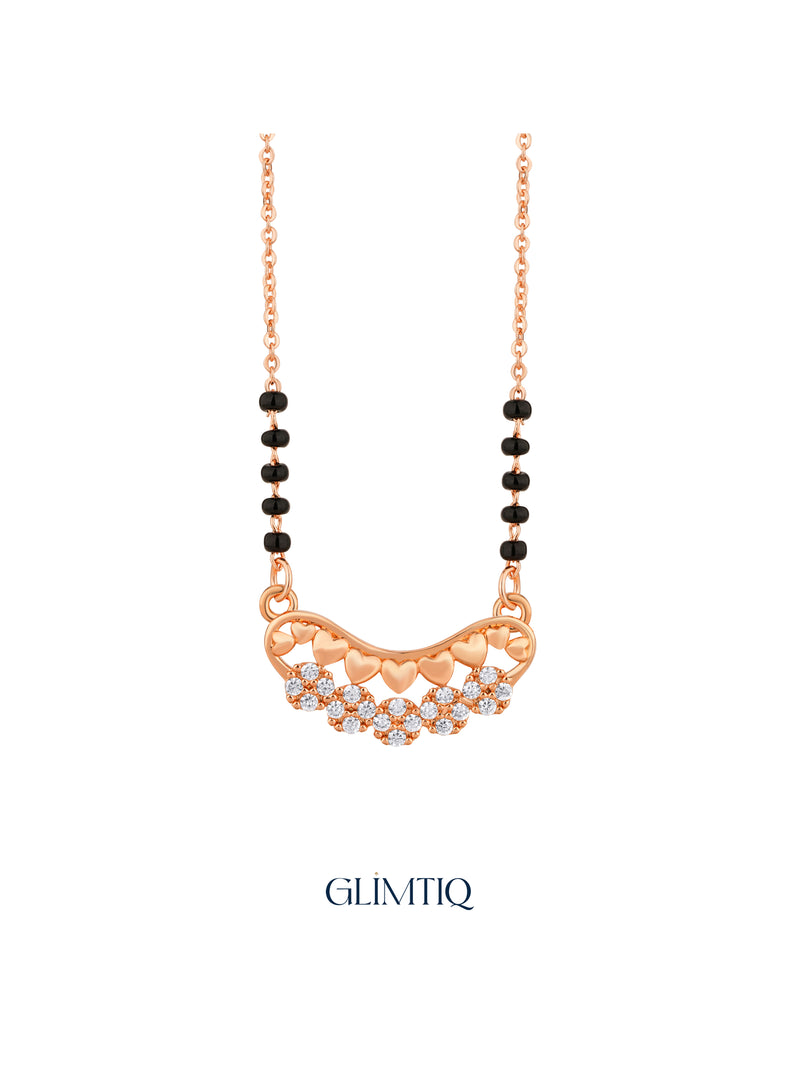 Close-up of rose gold mangalsutra pendant featuring curved row of rose-gold hearts above sparkling flower clusters.