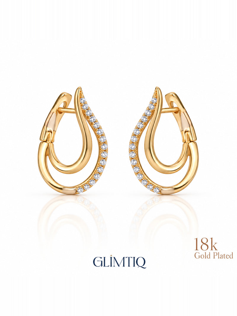 Close view of golden swoop 18k gold plated huggie earrings showing double-curve huggie with clear accents on the outer curve