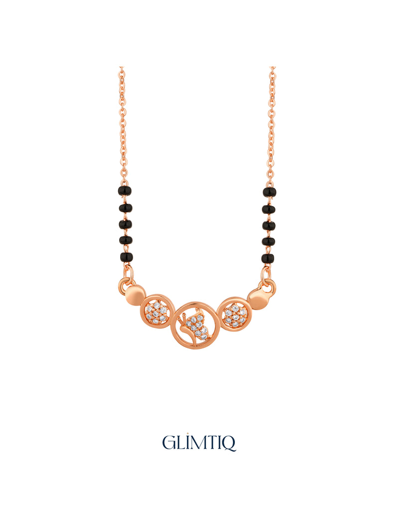 Close-up of rose gold mangalsutra pendant featuring peacock motif in a centre circle with two sparkling floral circles.