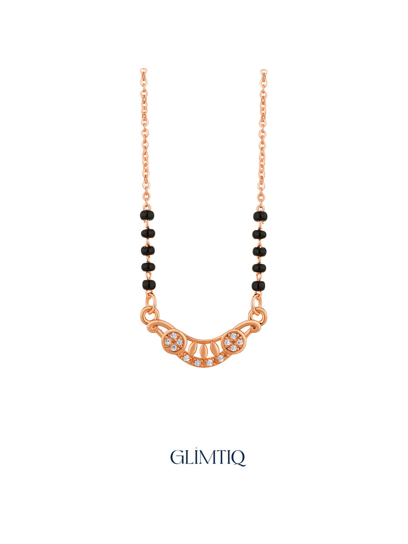 Close-up of rose gold mangalsutra pendant featuring crescent pendant with two sparkling flowers and petal details.