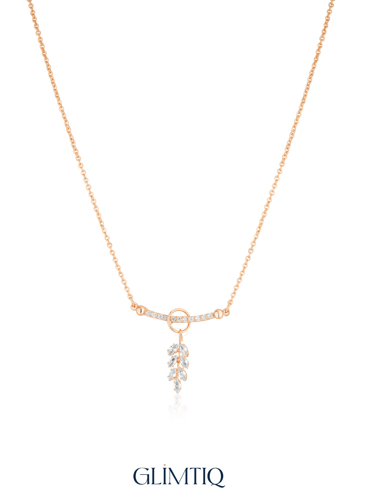 Gold necklace studio view with open circle, sparkling curved bar and hanging leaf drop