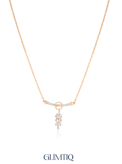 Gold necklace studio view with open circle, sparkling curved bar and hanging leaf drop
