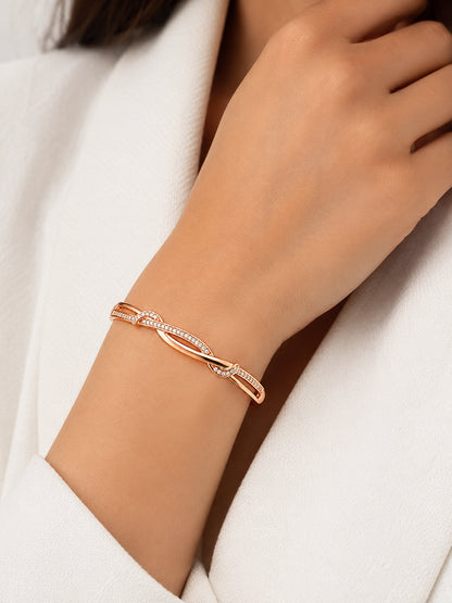 Sparkling Twist rose gold plated bracelet worn on wrist with a light blouse