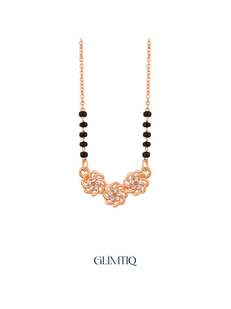 Close-up of rose gold mangalsutra pendant featuring three sculpted rose swirls with sparkling floral centres.