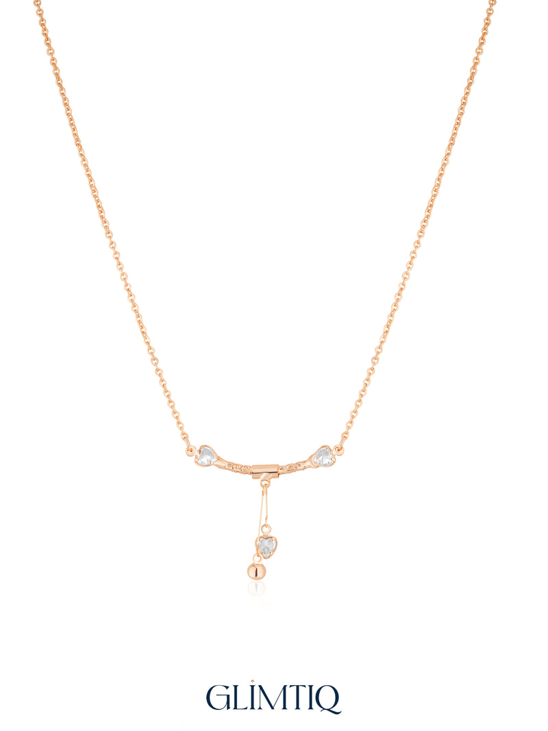 Gold Twin Heart Drop necklace studio view showing two heart accents and a hanging heart with gold bead