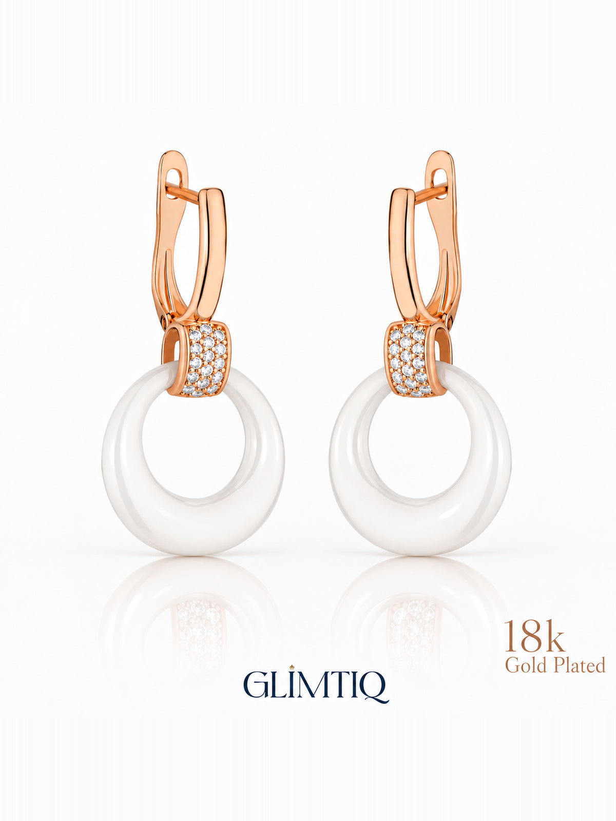 Close view of white halo 18k rose gold plated drop earrings showing white circular drop with a sparkling connector